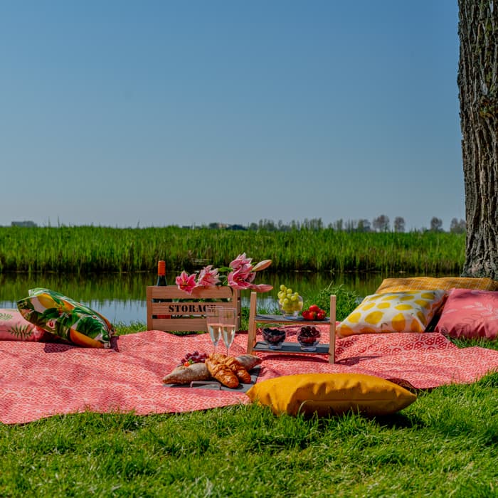 Picknickdecke mit buntem Motiv auf Terrasse ausgebreitet