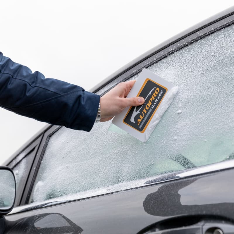Eiskratzer in der Hand eines Autofahrers
